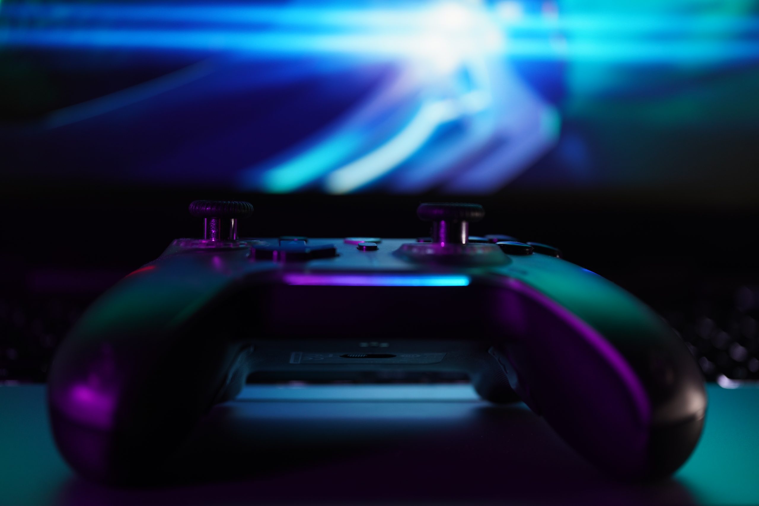 Ein Gamepad auf einer Tastatur, im Hintergrund unscharf ein Buildschirm